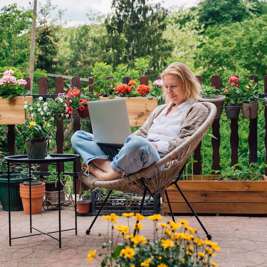 relaxed woman in garden learning on a laptop